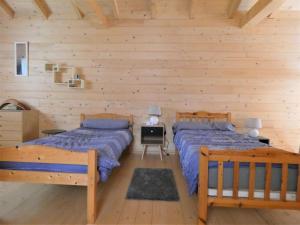 2 camas en una habitación con paredes de madera en La cle des champs, en Dax