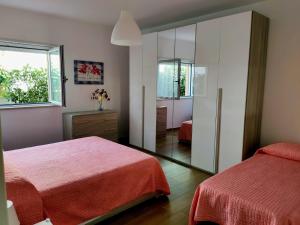 ラクイラにあるVillino Maria Pia, appartamento in villino in centro storico L'Aquilaのベッドルーム1室(ベッド2台、鏡付)
