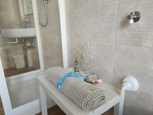 a bathroom with a bench with a shower and a sink at Villino Maria Pia, appartamento in villino in centro storico L'Aquila in LʼAquila