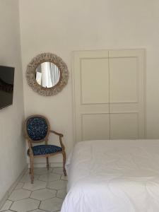 una camera con letto, specchio e sedia di ELISA ROOMS a Capri