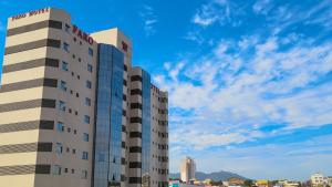 a tall building in front of a blue sky at Faro Hotel Atibaia in Atibaia