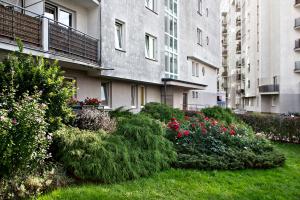 un jardín con flores y arbustos frente a un edificio en P&O Apartments Bielany, en Varsovia