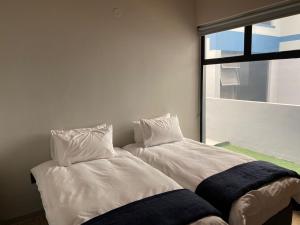 due letti uno accanto all'altro in una stanza di DieStrandwolf Sea View Self Catering a Hentiesbaai