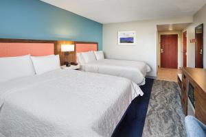 a hotel room with two beds and a television at Hampton Inn Melbourne-Viera in Melbourne