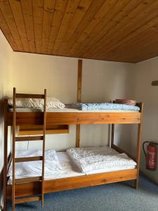 two bunk beds in a room with a wooden ceiling at Feriendorf Kimbucht in Reichendorf