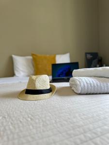 リスボンにあるEy Lisbon GuestHouseのベッドの上に座る帽子(タオル付)