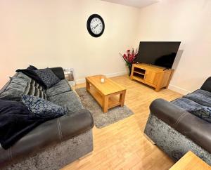 a living room with a couch and a television at April Disc - Long Stay - Contractors in Swindon