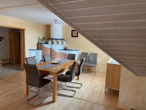 a dining room with a wooden table and chairs at Ferienwohnung zur Bugspitze in Selbitz