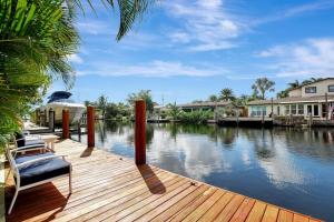 a wooden dock with chairs on top of a body of water at Wilton on the water courtyard and Heated Pool in Fort Lauderdale