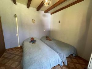 twee teddyberen op een bed in een slaapkamer bij Le mont in Saint-Geours-de-Maremne