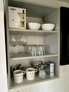 una estantería con platos y copas de vino en la cocina en Flat near BTC city - free parking en Liubliana
