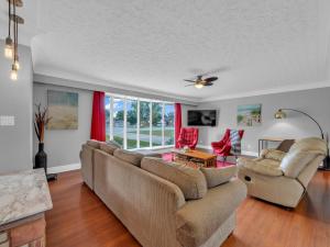 a living room with a couch and chairs and a window at Park Bungalow - Seacliff Beach Suites in Leamington