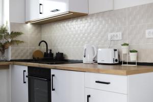 Vrh Apartman في ديفشيبار: مطبخ مع أجهزة بيضاء على منضدة
