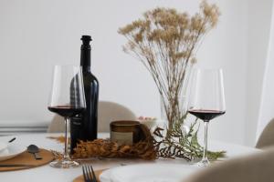 einen Tisch mit zwei Weingläsern und einer Flasche Wein in der Unterkunft Vrh Apartman in Divčibare