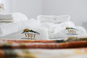 einen Haufen weißer Handtücher auf dem Tisch in der Unterkunft Vrh Apartman in Divčibare
