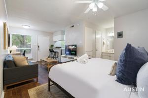 a bedroom with a large white bed and a living room at 1st Floor Apt Hyde Park Bathtub and Free Parking in Austin