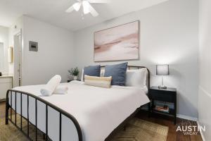 a bedroom with a large white bed with blue pillows at 1st Floor Apt Hyde Park Bathtub and Free Parking in Austin
