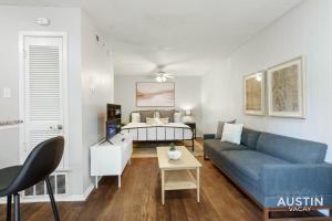 a living room with a blue couch and a bed at 1st Floor Apt Hyde Park Bathtub and Free Parking in Austin
