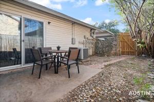 a patio with a table and chairs in front of a house at Walk to Barton Springs Spacious Apt Backyard in Austin