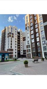 a group of tall buildings with a bench in a courtyard at Airport-apartament 24&24 Chişinău!!! in Chişinău