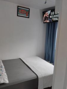 1 dormitorio con 1 cama y un cartel en la pared en HORTA DO TOMATE en Bombinhas