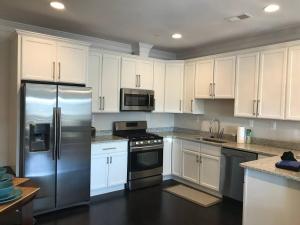 a kitchen with white cabinets and stainless steel appliances at Entire Extra Large Luxury 3 Bedrooms Condo in Washington