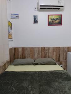 a bedroom with a bed and a heater on the wall at HORTA DO TOMATE in Bombinhas