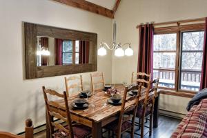 - une salle à manger avec une table et des chaises en bois dans l'établissement Plateau B - Mont-Tremblant, à Mont-Tremblant