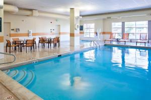 a swimming pool with chairs and tables in a building at Courtyard by Marriott Pueblo in Pueblo