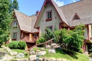 une grande maison avec un toit en gambrel dans l'établissement Plateau B - Mont-Tremblant, à Mont-Tremblant