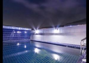 an empty swimming pool at night with lights at Patong Dynasty Royal Hotel in Patong Beach