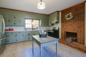 a kitchen with a table and a brick wall at Historic Raphine Retreat Near Brownsburg Village! in Raphine
