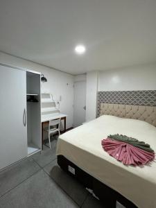 una camera da letto con un letto con un vestito rosa di APÊ 102, 2 QUARTOS, TÉRREO | WI-FI 600MB | RESIDENCIAL JC, um lugar para ficar. a Belém