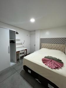 a bedroom with a bed with a pink dress on it at APÊ 102, 2 QUARTOS, TÉRREO | WI-FI 600MB | RESIDENCIAL JC, um lugar para ficar. in Carmo