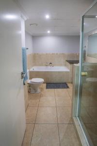 a bathroom with a tub and a toilet and a shower at Stay at the Point - Harbour Haven in Durban