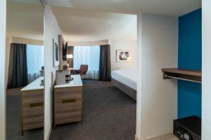 Habitación de hotel con cama y escritorio en Crowne Plaza Atlanta NE - Norcross en Norcross