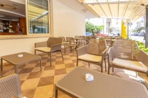un restaurante con sillas y mesas en una habitación en Hotel Ribot en Rímini