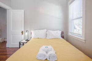 een slaapkamer met een geel bed en handdoeken bij The Villa 1B Downtown Covington by St. Elizabeth in Covington