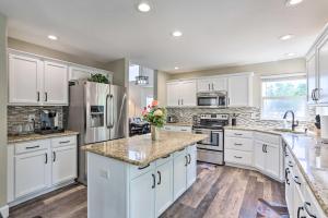 una cocina con armarios blancos y encimeras de mármol en Spacious Thornton Home 11 Miles to Dtwn Denver, en Thornton