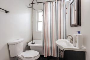 ein Bad mit einem WC, einem Waschbecken und einem Fenster in der Unterkunft The Villa Emerald 1B Walk to Downtown Covington in Covington