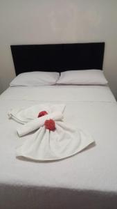 a white bed with two white towels on it at Condomínio Golden Goes in Porto Seguro