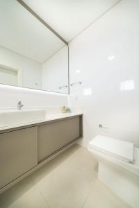 Baño blanco con lavabo y aseo en 161 - Cobertura de Luxo com Vista Mar em MARISCAL, en Bombinhas