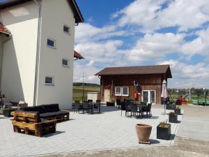 a large patio with a building and tables and chairs at Ferienwohnung auf dem Traubshof in Ochsenhausen