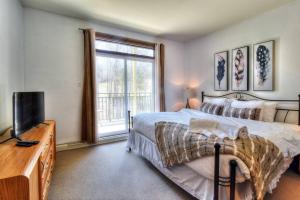 une chambre avec un lit, une télévision et une fenêtre dans l'établissement Tremblant-Les-Eaux C1, à Mont-Tremblant 25 autres photos