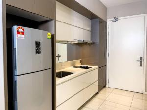 een witte keuken met een koelkast en een wastafel bij Skypool Couple Suite in Sri Hartamas KL in Kuala Lumpur