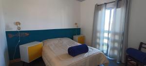 a small bedroom with a bed and a window at Balconada Beach ROOMS in La Paloma