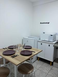 a table with plates and wine glasses on it in a kitchen at Apartamento em Uberlândia - Apê do Pedro in Uberlândia
