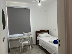a small bedroom with a bed and a desk at Apartamento em Uberlândia - Apê do Pedro in Uberlândia