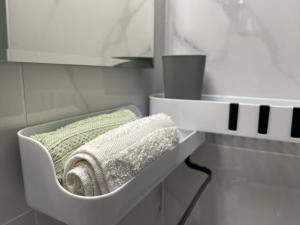 a bathroom with a sink with towels on a shelf at Ρετιρέ με θέα το Ηράκλειο in Heraklio Town