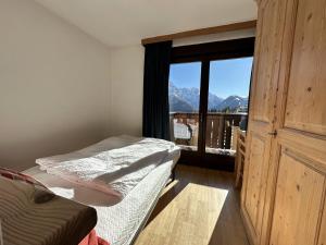 a bedroom with a bed and a window with a view at Hotel Betulla in Madonna di Campiglio